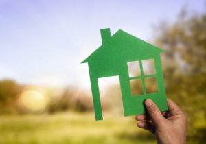 Scherenschnitt eines Hauses vor sonniger Landschaft